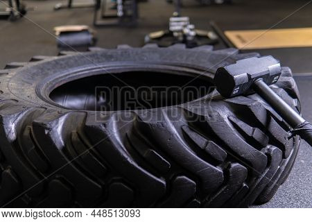 A Tire On A Black Background With A Sledgehammer Lies For Crosfit Fitness Wheel Sledgehammer Workout