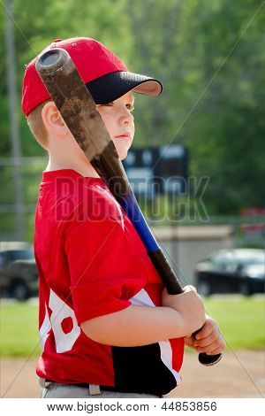 Retrato de criança, preparando-se para morcego durante jogo de beisebol da liga organizada