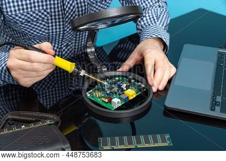 Cropped Image Of Male Hands Working With Motherboard Isolated Over Blue Background