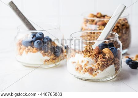Granola With Nuts, Yogurt And Berries In A Jar. Breakfast Parfait With Muesli, Yoghurt And Blueberri