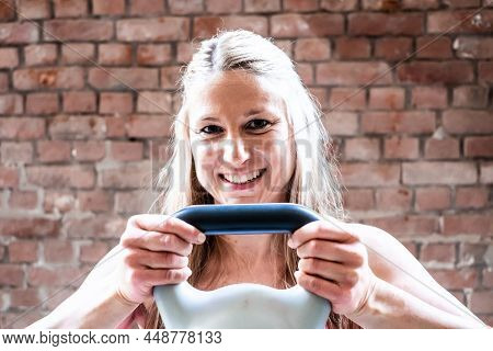 Young Muscular Woman Doing High Pull Exercise With Kettlebells On Hard Training At The Garage Gym. H