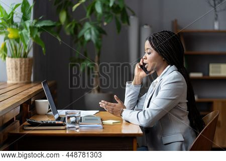 African-american Businesswoman In Formal Outfit Using Mobile Phone, Making Phonecall In Workplace, A