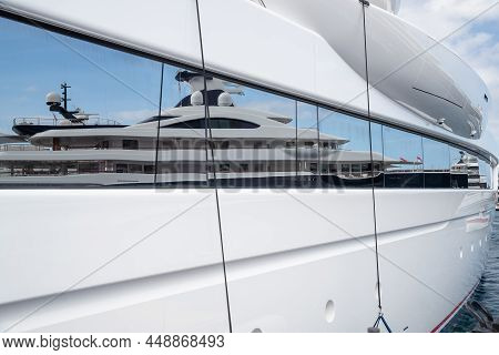 Reflection Of A Boat On A Glossy Surface Of A Huge Yacht At Sunny Day, The Chrome Plated Handrail, M