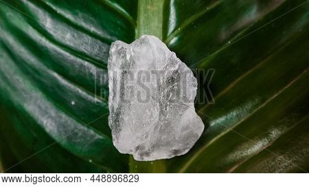 Crystal clear alum cubes or Potassium alum on green leaf. Chemical compound substance. Concept for b