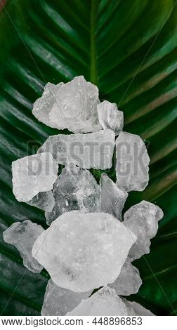 Crystal clear alum cubes or Potassium alum on green leaf. Chemical compound substance. Concept for b