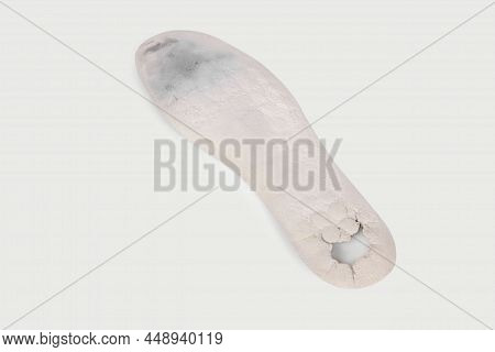 Old And Shabby Orthopedic Insoles Isolated On White Background. Dirty Leather Insoles. Worn Out Thin