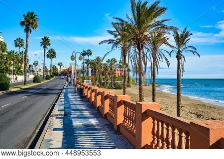 Benalmadena, Spain - Dec 17, 2019: Sandy Beach, Mediterranean Sea, Palm Trees View Next To Seafront 