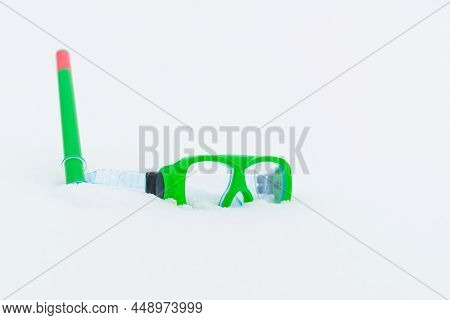 Snow Fun. Green Diving Goggles,snorkel On White Snow.scuba Snorkeling Green Diving Set Flat Lay On T