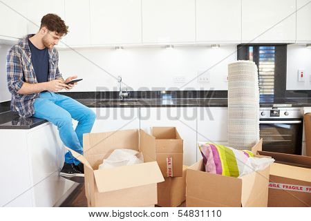 Man Sending Text Message Having Moved Into New Home