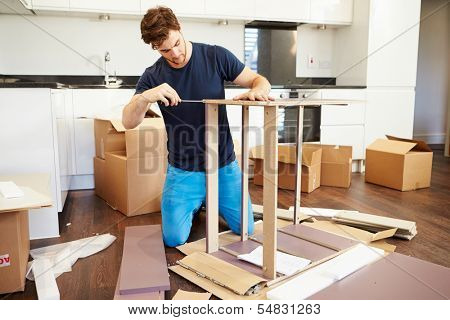 Man Putting Together Self Assembly Furniture In New Home
