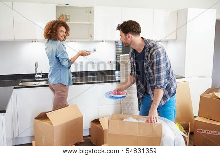Couple Moving Into New Home And Unpacking Boxes