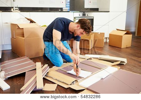 Man Putting Together Self Assembly Furniture In New Home