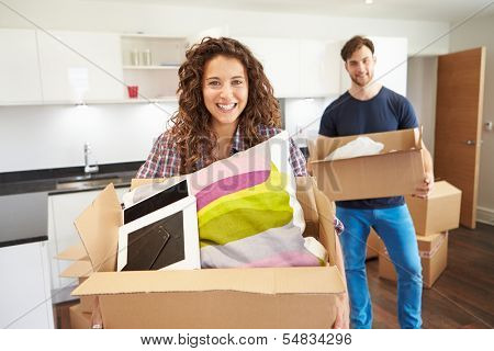 Couple Moving Into New Home And Unpacking Boxes