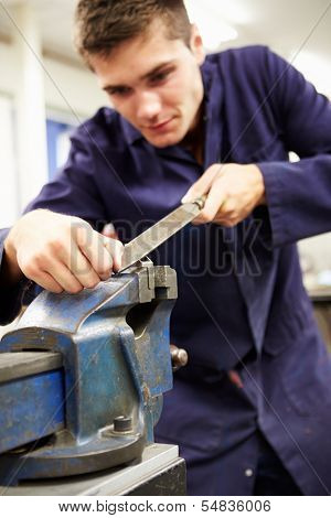 Apprentice Engineer Working On Factory Floor
