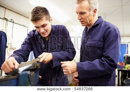 Engineer Checking Trainee's Work On Factory Floor
