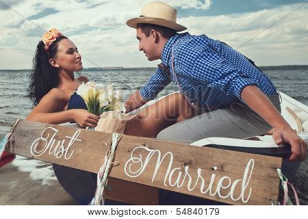 Romantic young couple cuddling in rowboat at lake
