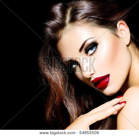 Sexy Beauty Girl with Red Lips and Nails. Provocative Make up. Luxury Woman with Blue Eyes. Fashion Brunette Portrait isolated on black background. Gorgeous Woman Face. Long Hair 