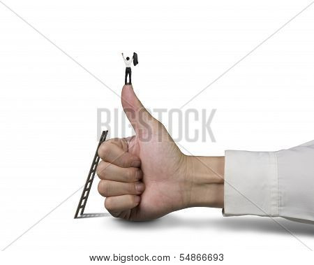 Businessman Standing On Top Of Thumb With 2 Hands Up