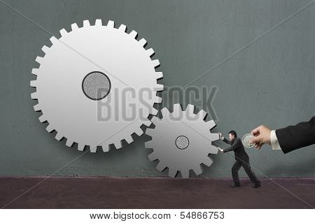 Hand Hold Coin Insert Into Businessman Back Rotating Large Gear