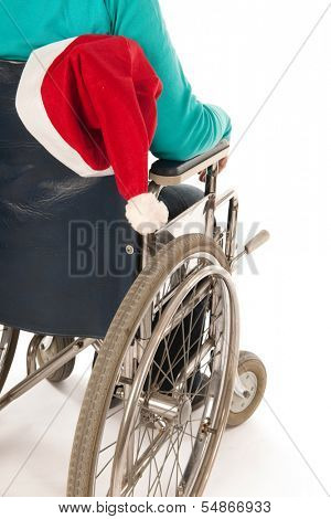 Person riding in wheelchair with Christmas hat from Santa Claus