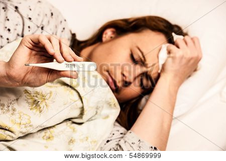 Woman checking feaver with digital termomether girl with flu