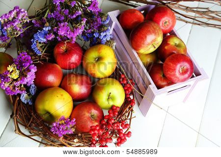 Juicy apples in box on white wooden table