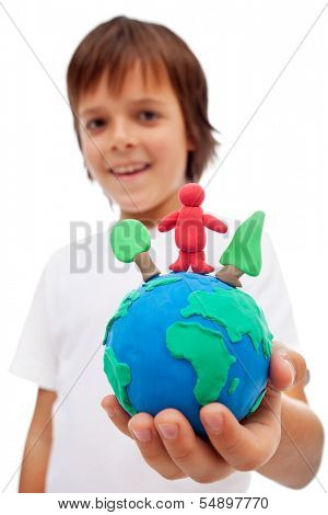 Life in harmony with nature concept - boy holding earth globe with trees and man made of colorful clay