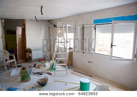 House indoor improvements in a messy room construction with plaste tools and ladder