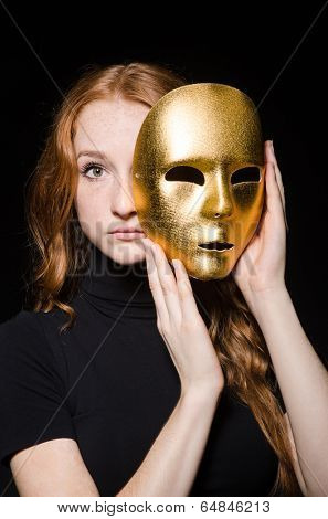 Redhead woman iwith mask in hypocrisy consept against black  background