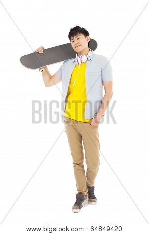 Young Man Standing And Holding A Skateboard
