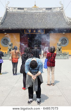 SHANGHAI, CHINA - APRIL 9, 2014: The faithful are praying in Longhua buddhist temple