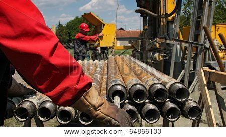 Drilling Rig And Two Oil Workers