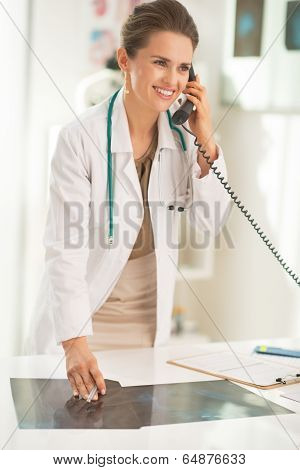 Happy Medical Doctor Woman With Fluorography Talking Phone In Office