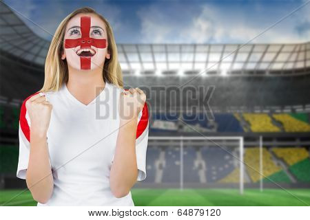 Excited fan england in face paint cheering against football pitch in large stadium