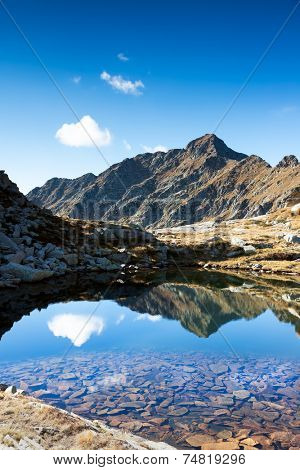 Mont Mars reflected in the Rosso lake in a sunny autumn day. Biella, Piemonte, West italian Alps, Europe.