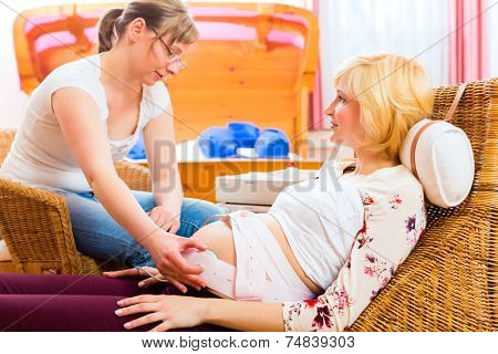 Midwife examination belly of pregnant woman with CTG scanning in practice