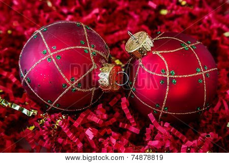 Christmas decorations lying on a bed of crinkle cut shredded paper.