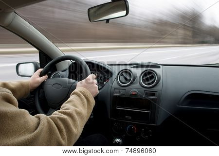 Man driving car on road, blurred motion