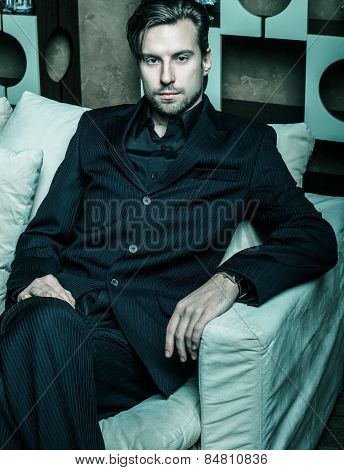 Businessman sitting on an armchair. Fahion man.