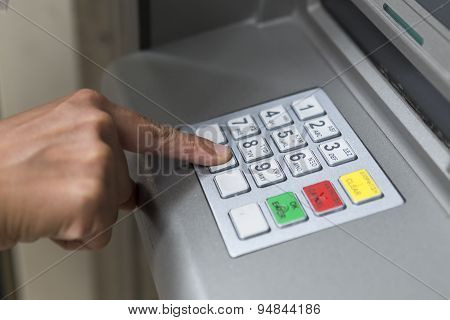 People Stand In A Queue To Use The Atms Of A Bank. Person Receiving Money From The Atm.
