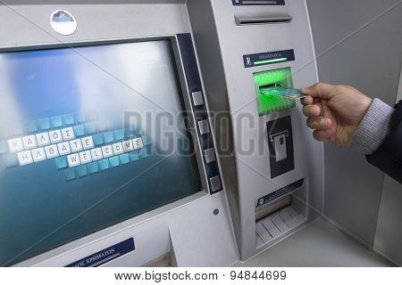 People Stand In A Queue To Use The Atms Of A Bank. Person Receiving Money From The Atm.