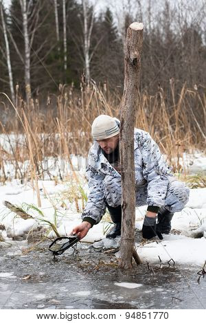 The Hunter Pulls The Trap Out Of The Water