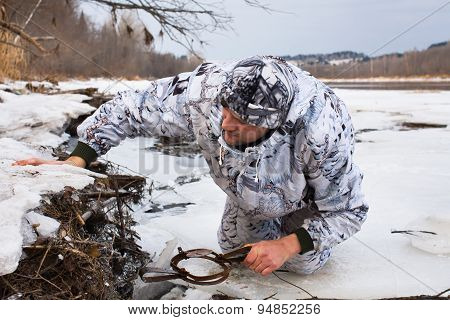 Hunter Putting A Leghold Trap For Beaver