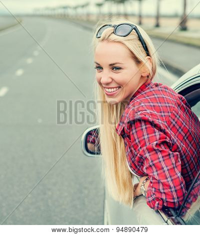 Happy Young Woman Looking Out From Car Window