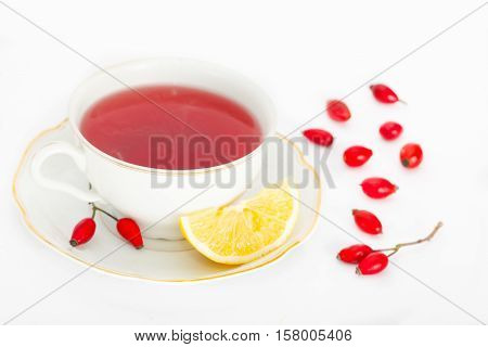 Cup of healthy rosehip tea with lemon slice on white background