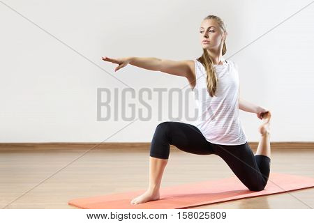 Young fit woman works out in the fitness class. Yoga asana. Space for placing text.