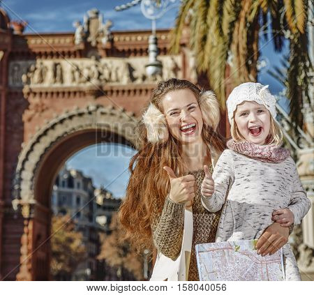Mother And Child Near Arc De Triomf With Map Showing Thumbs Up