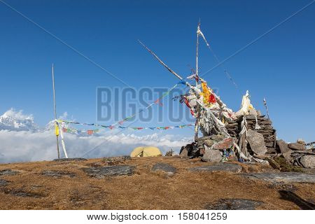 Camping Tent On The Top Of The Pikey Peak Mountain Next To Buddhist Chorten And Waving Prayer Flags.