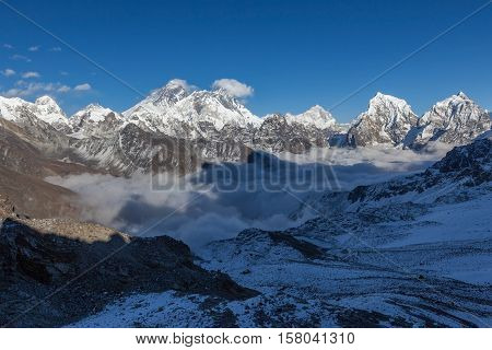 Mount Everest View From Renjo La Pass. Picturesque Mountain Valley Filled With Curly Clouds. Dramati