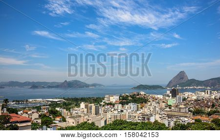 Aerial view of Guanabara bay, Sugarloaf mountain, residental buildings and Santa Amaro slum favela of Rio de Janeiro, Brazil